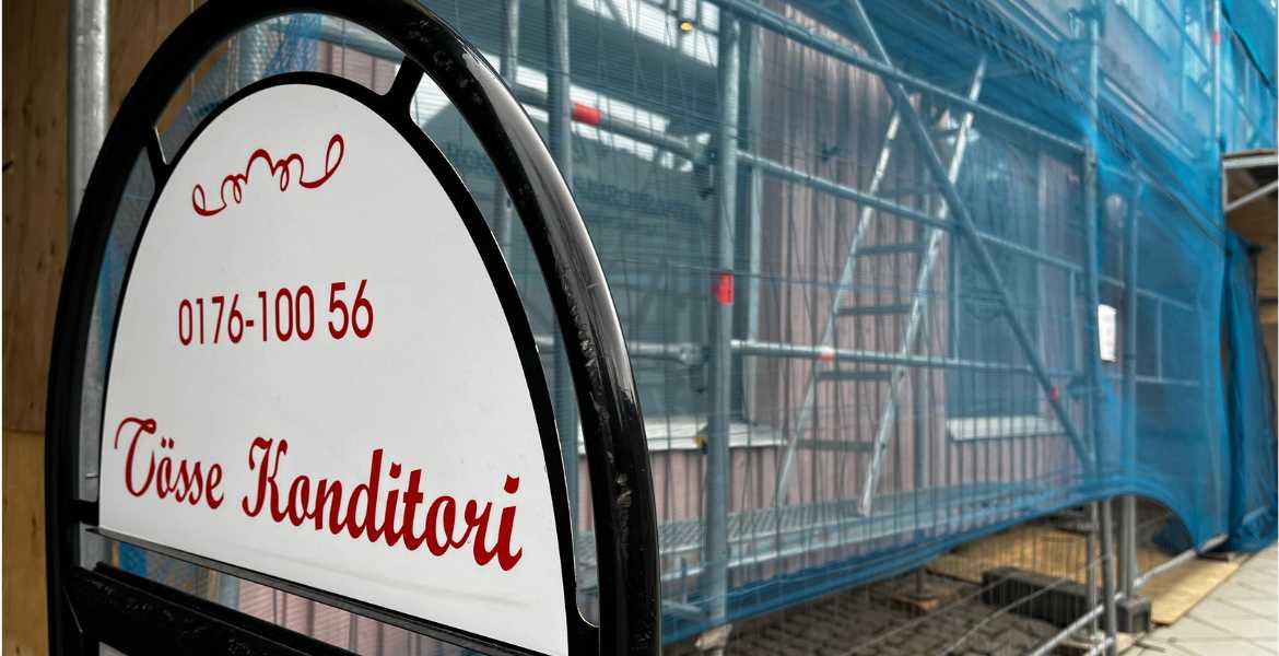 Tösses rosda fasd med byggställningar för förberedelse till omålning till grönt.