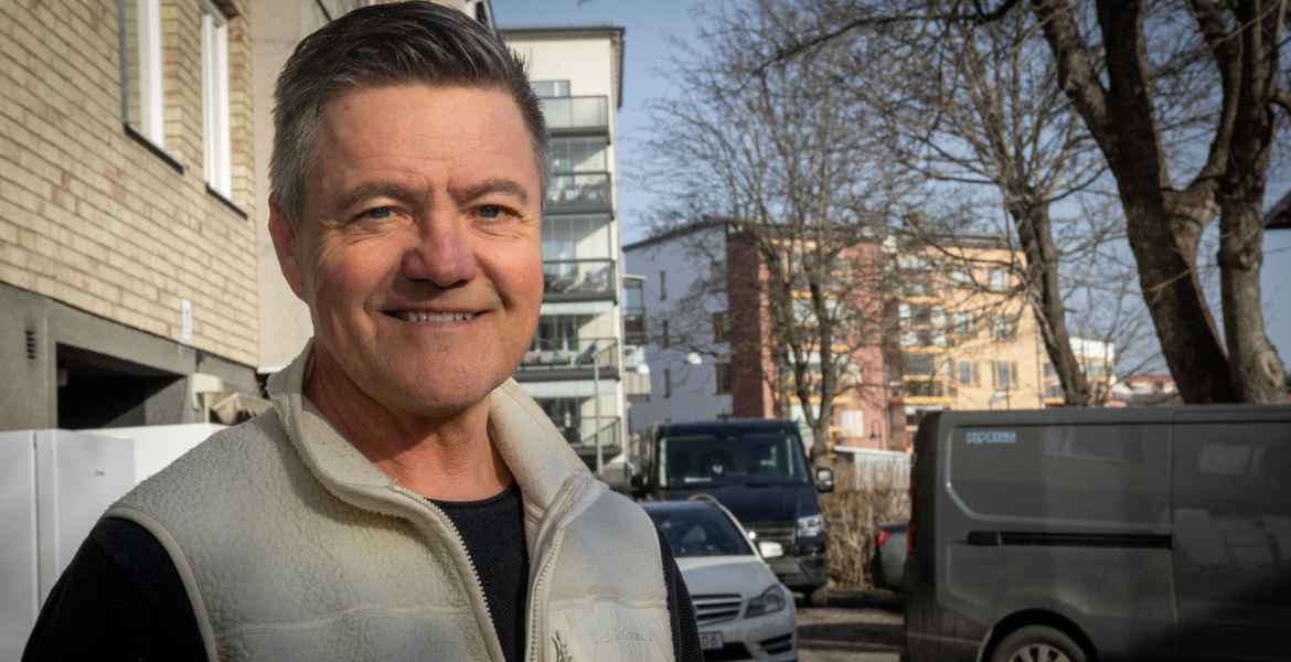 Kent Rensvik framför ett flerbostadshus.